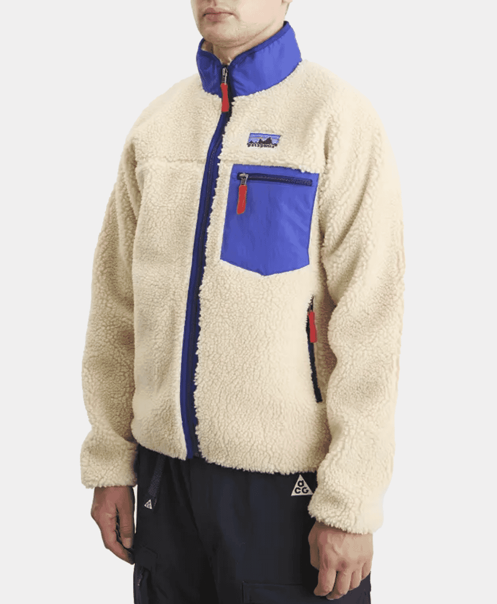 A man modeling the cream-colored Retro-X fleece jacket with blue and red details.