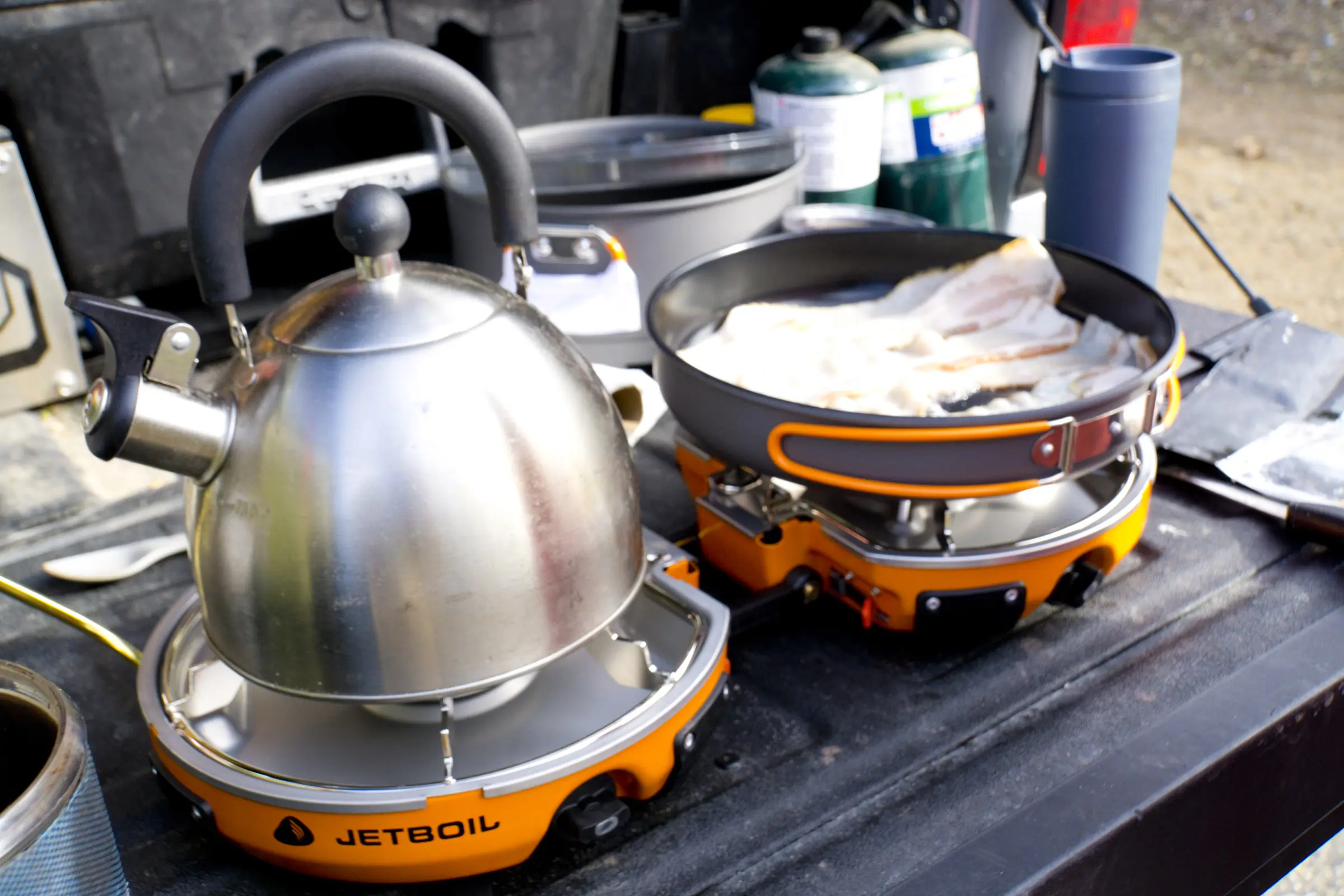 A Jetboil Genesis Basecamp stove set up on a car camping table.