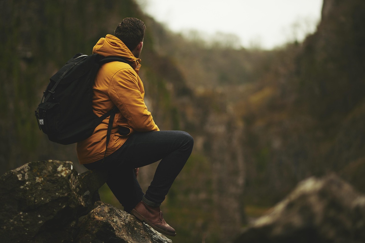 A seasoned hiker looking out over a vast mountain range with professional gear.
