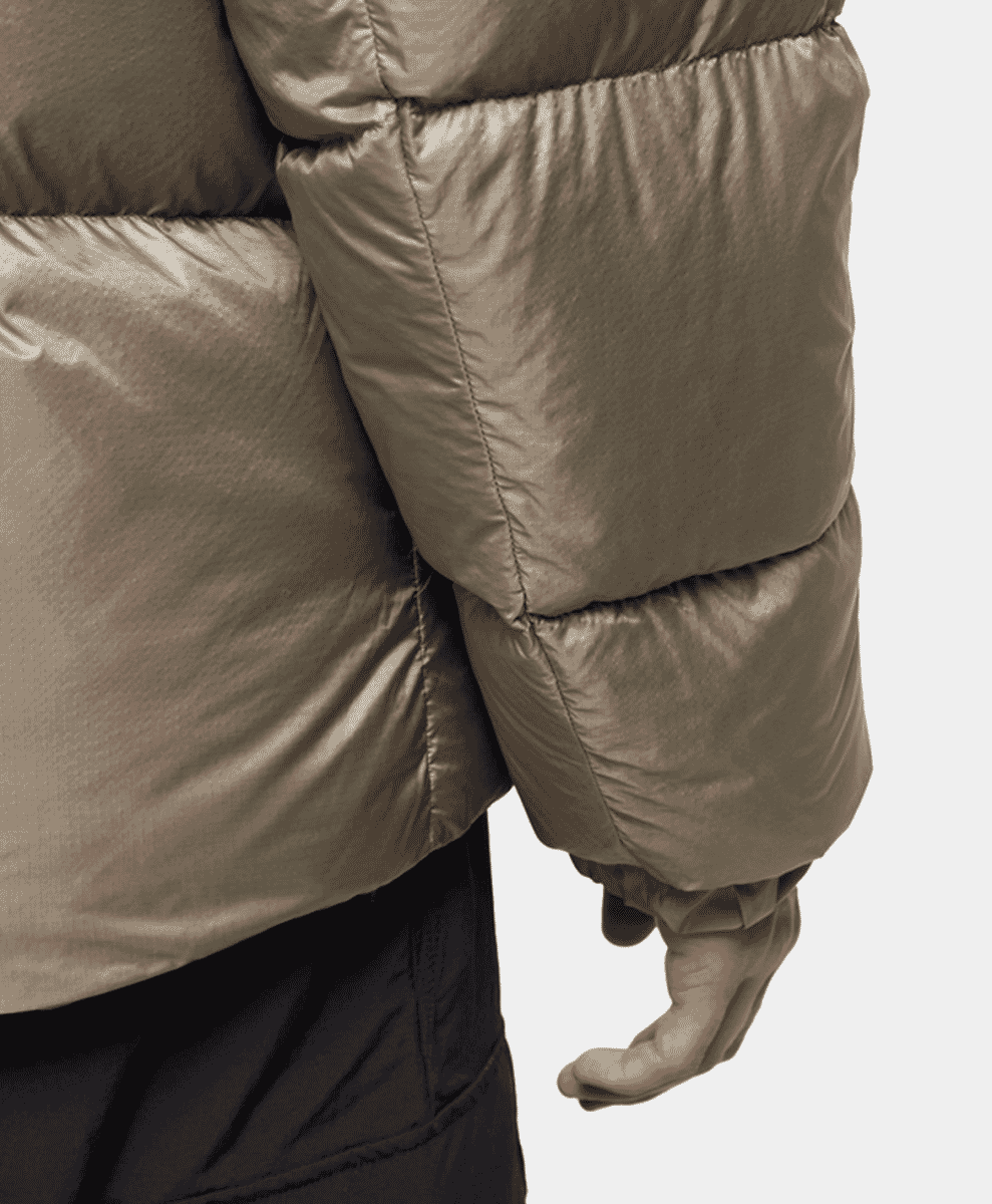 Close-up of the metallic taupe quilted fabric of a Goldwin jacket.
