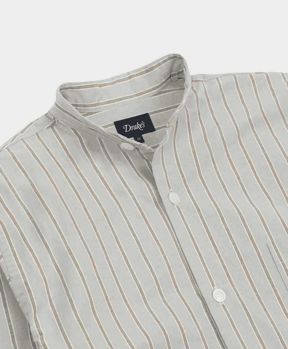 Close-up of a Drake's light-colored striped shirt with a mandarin collar and white buttons.