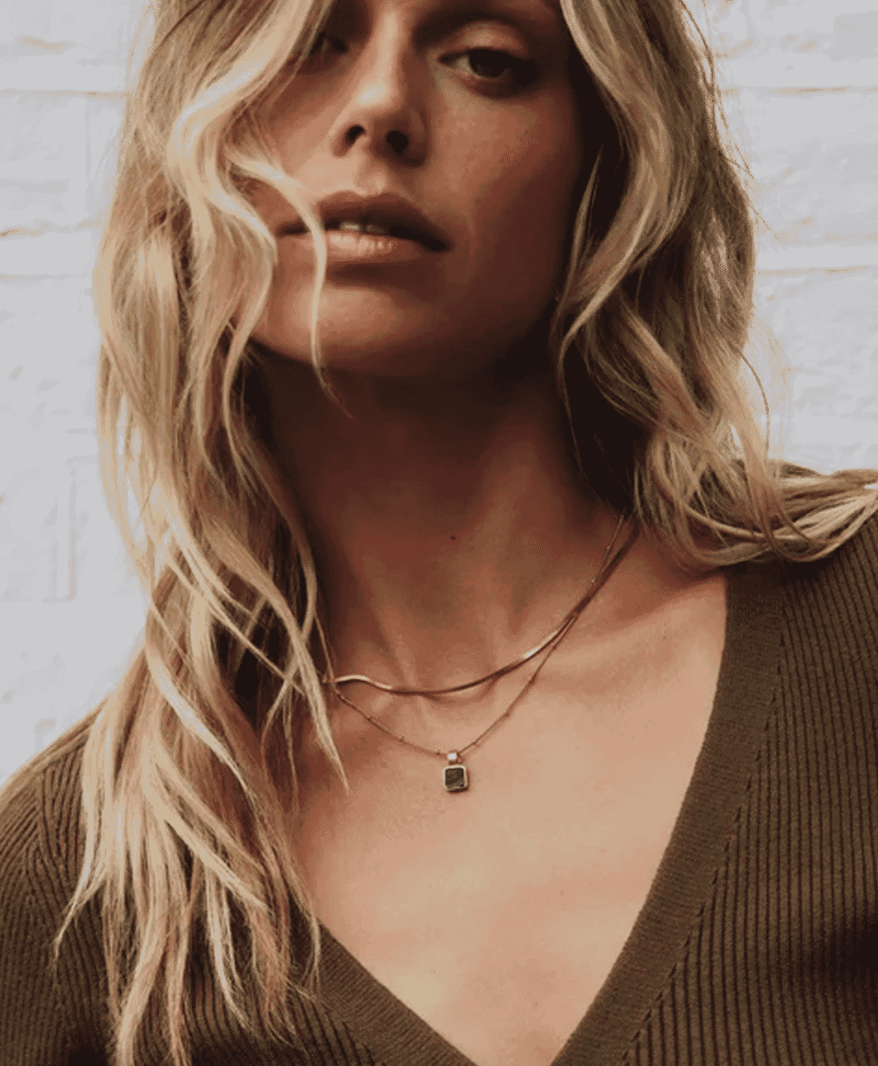 A woman wearing a square malachite pendant necklace by Missoma x Lucy Williams.
