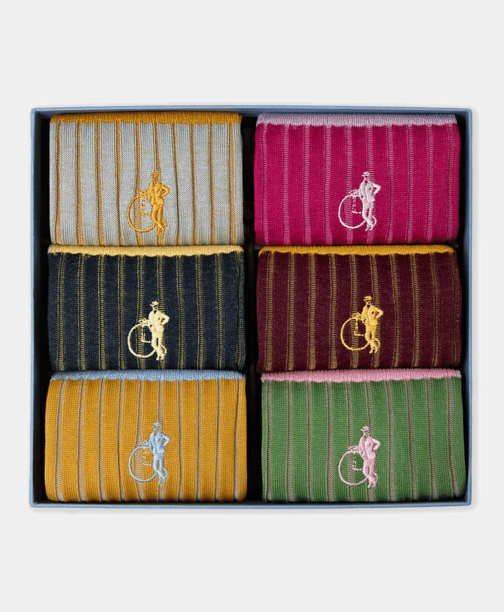 A gift box containing six pairs of colorful striped socks in a neat grid.