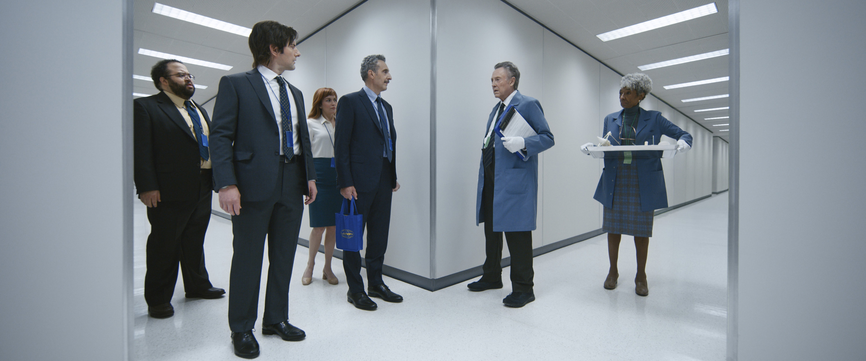 The core cast of Severance walking through a white Lumon hallway.
