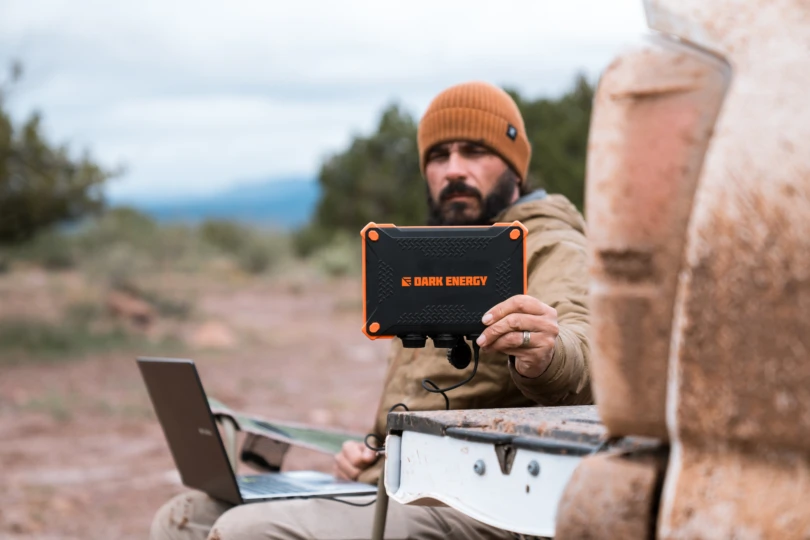 The Poseidon XL power pack sitting on a table in an outdoor camp setting.