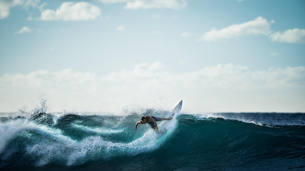 A professional surfer riding a massive, powerful wave on the Western Australian coast.