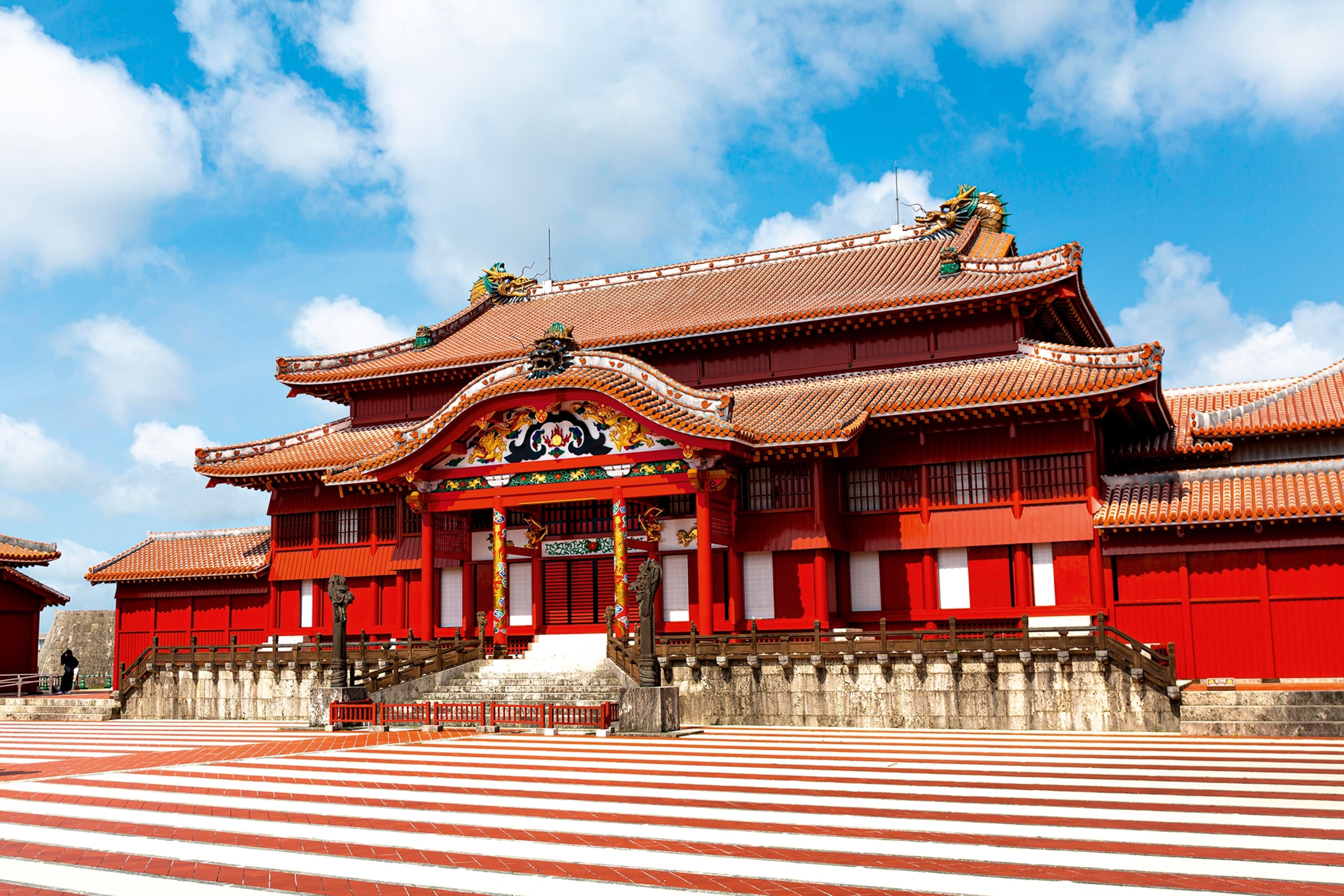 A traditional wooden temple gate surrounded by lush greenery in Japan.