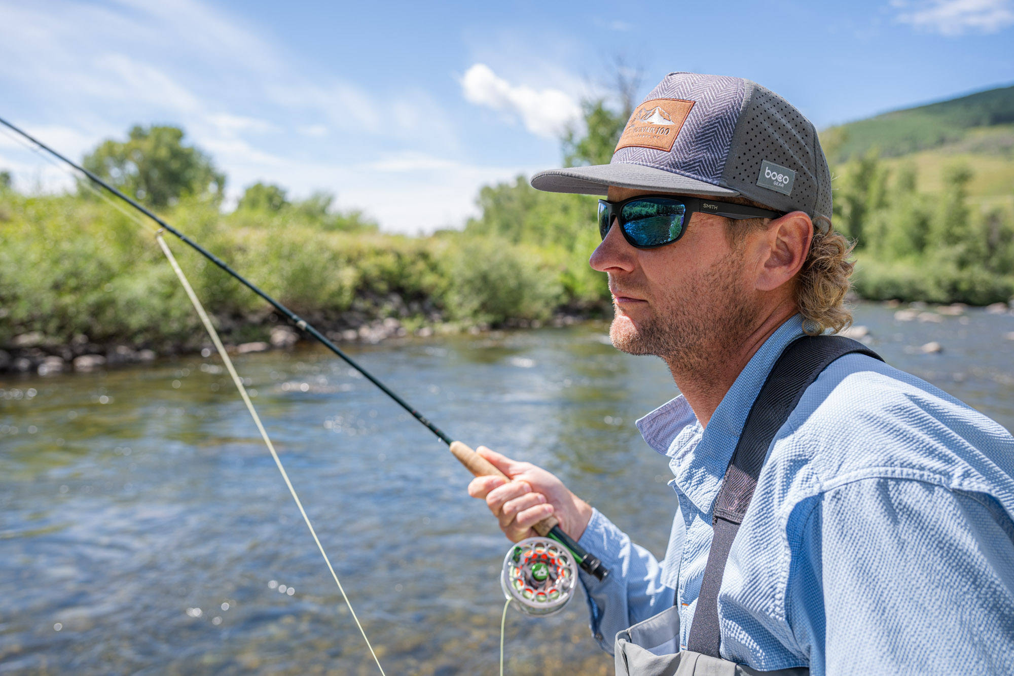Close up of an angler wearing polarized sunglasses while looking into the water.