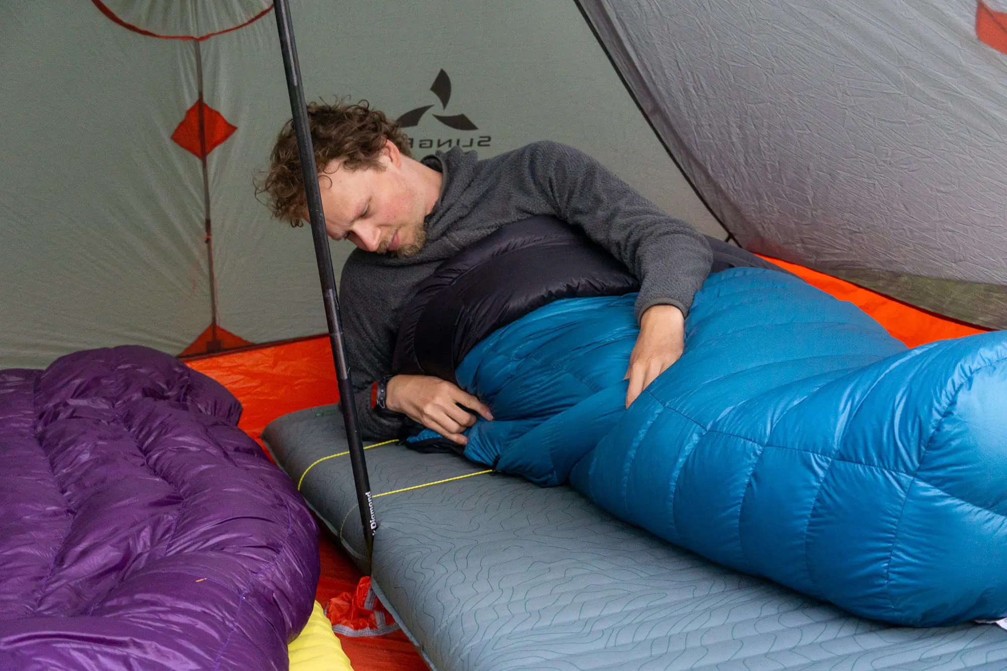 A classic mummy-style sleeping bag laid flat on the ground.