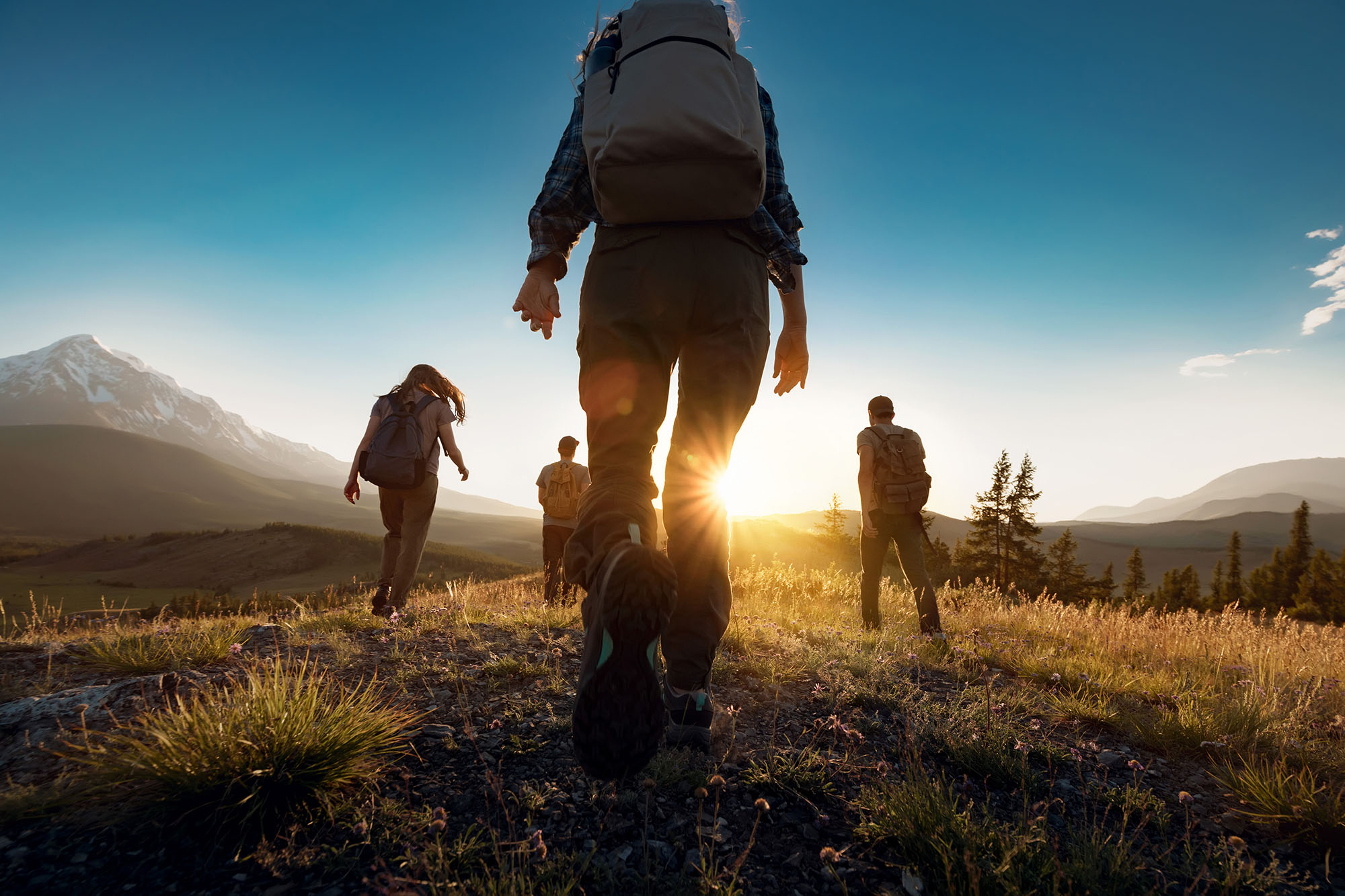 A group of backpackers hiking together on a mountain trail.