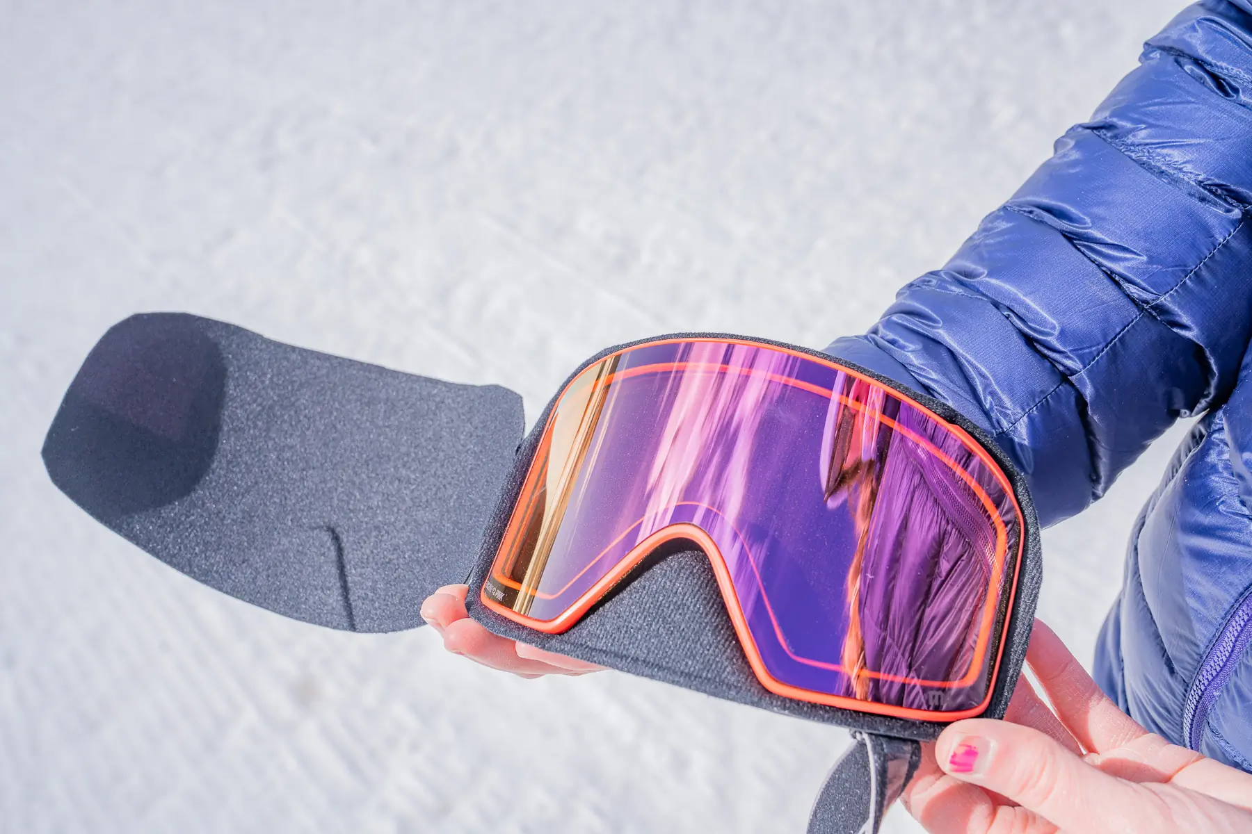 An Anon Perceive lens resting inside a protective hard-shell carrying case.