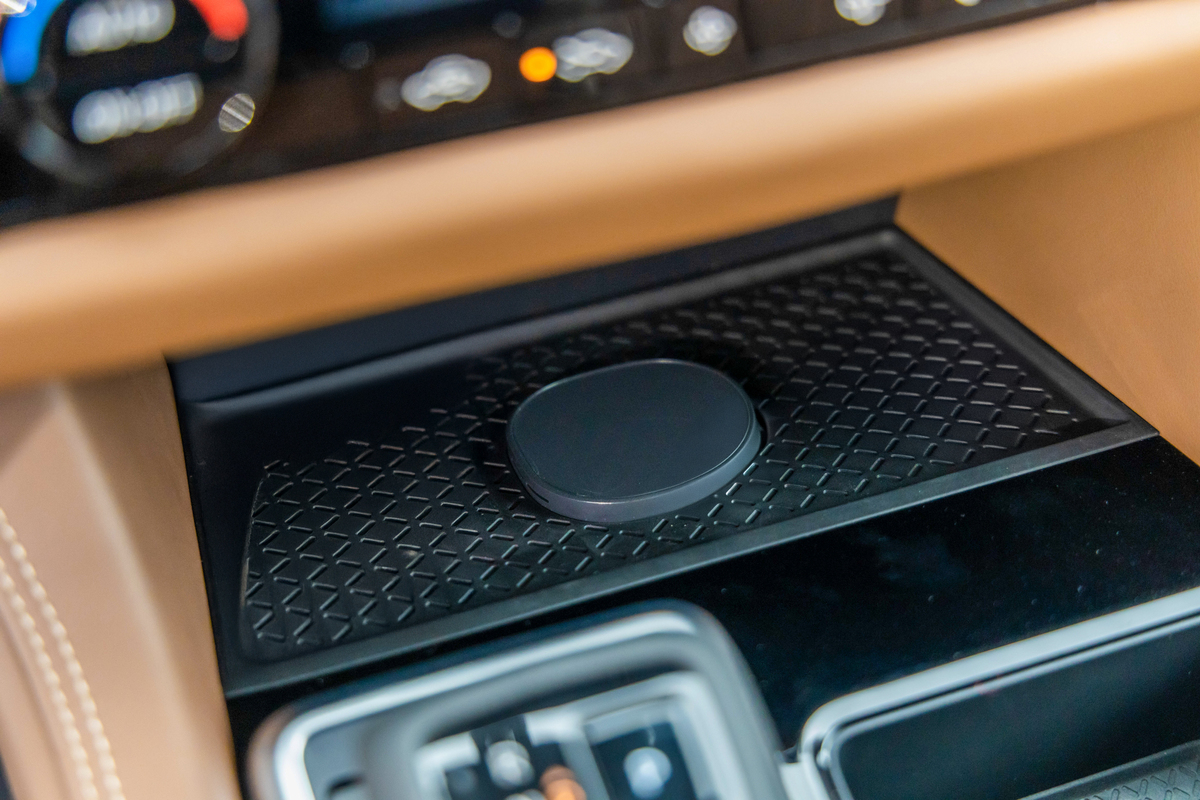 Close-up of a smartphone resting on the Nissan Pathfinder's magnetic wireless charging pad.