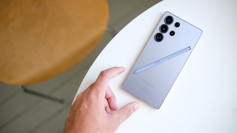 Samsung Galaxy S25 Ultra in a hand with the S-Pen stylus resting on the screen.