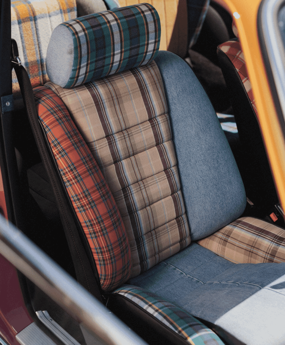 Detailed view of custom car seats featuring a mix of plaid, denim, and wool textures.