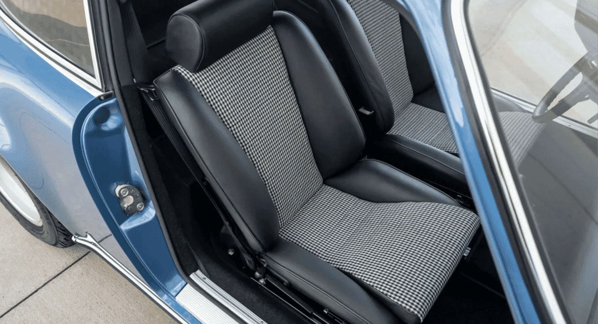 Close-up of Porsche interior featuring black leather and gray houndstooth Pepita fabric.