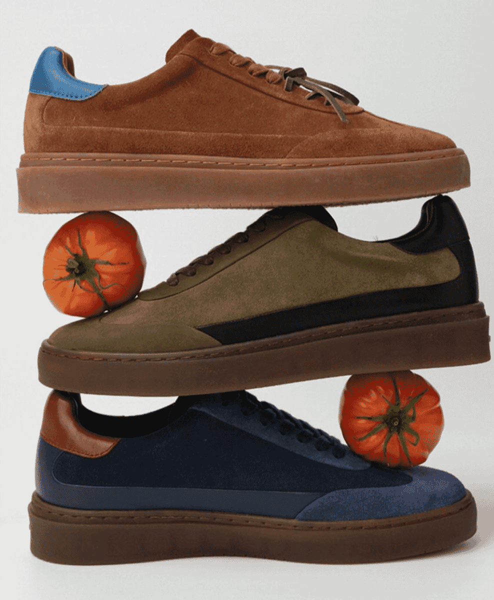 Three stylish suede sneakers in brown, olive, and navy stacked vertically with red tomatoes.