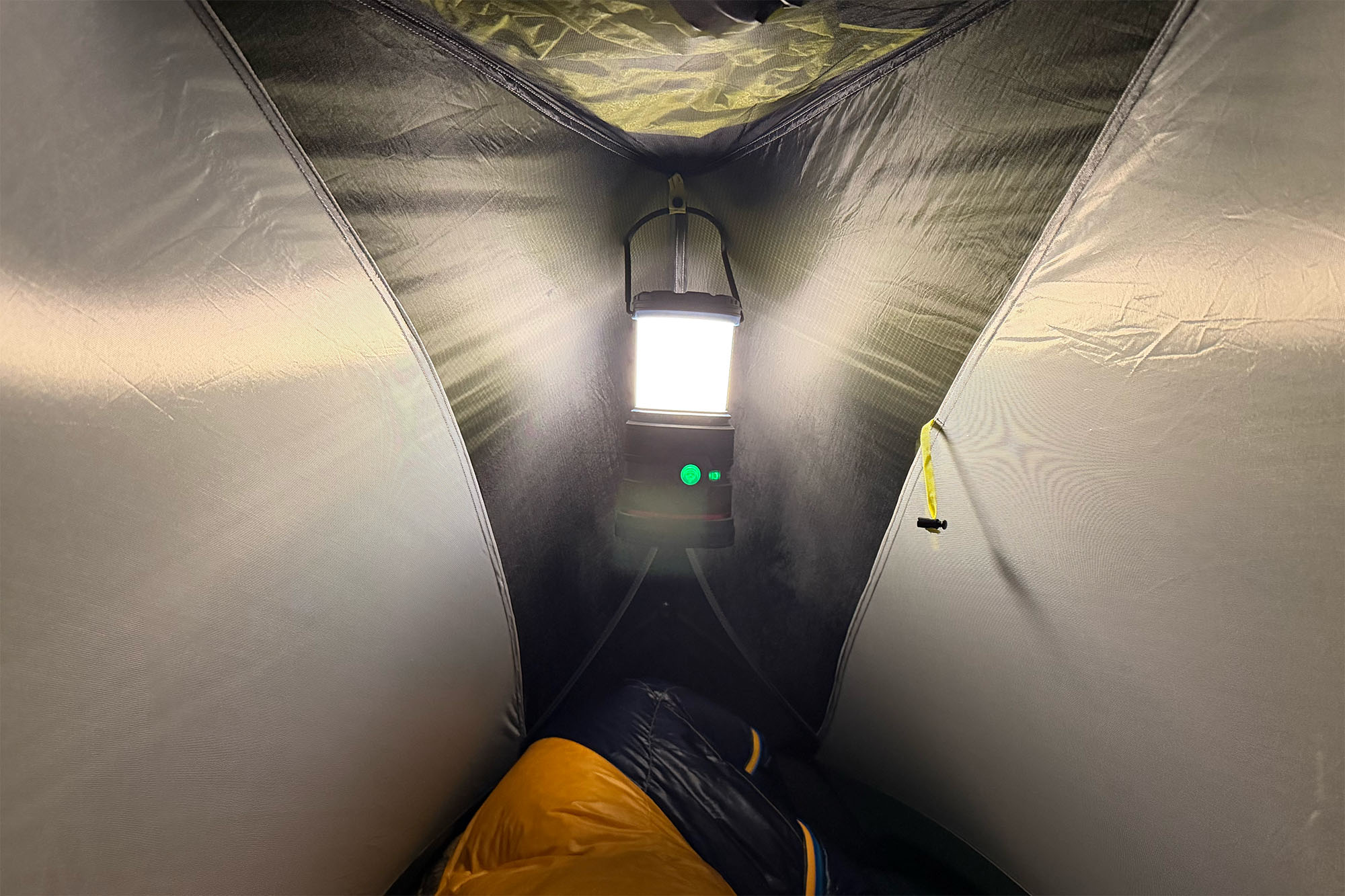 COAST EAL35R lantern hanging from the ceiling of a tent providing white light.