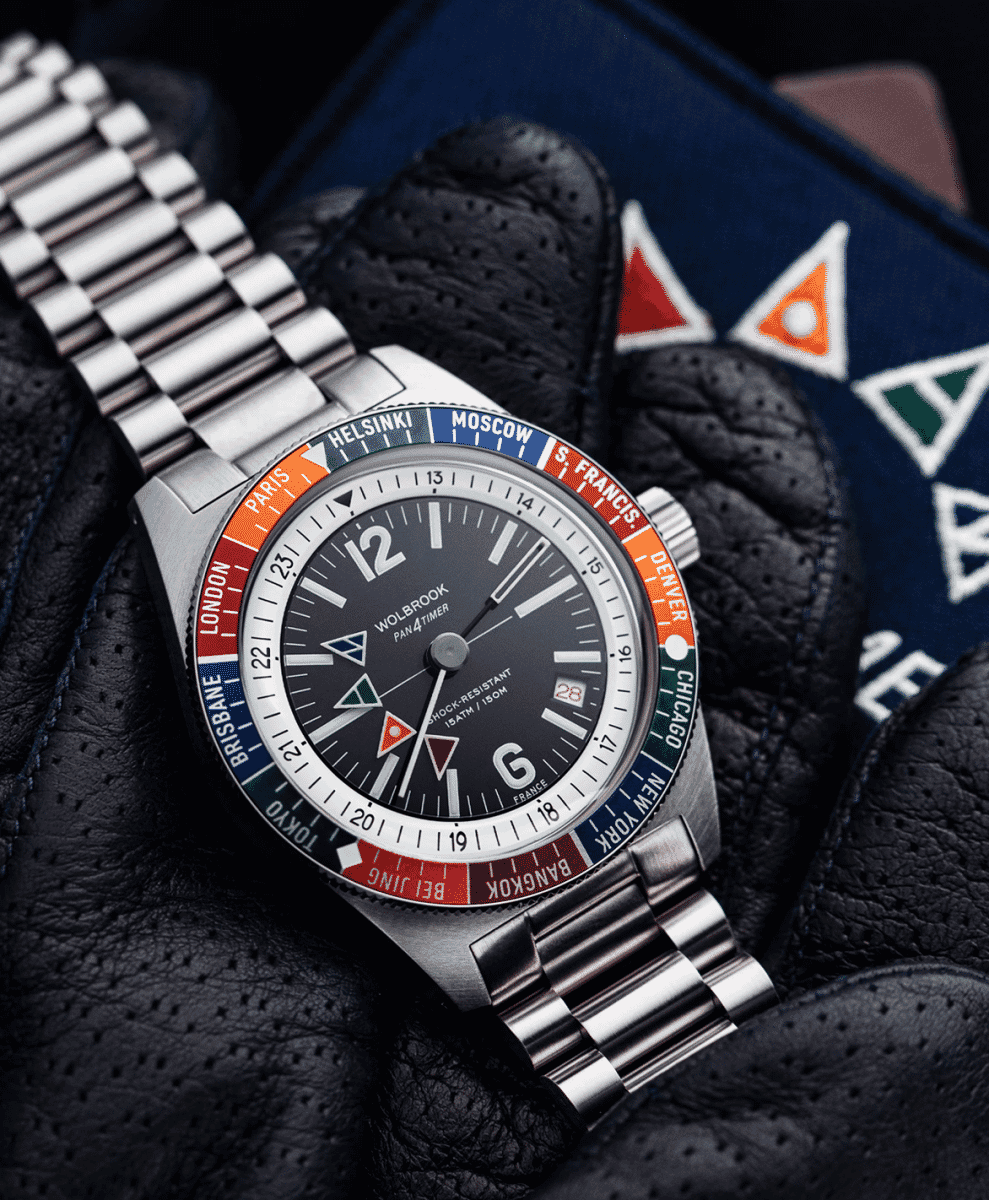 Close-up of the Wolbrook watch worn over a black perforated leather driving glove.