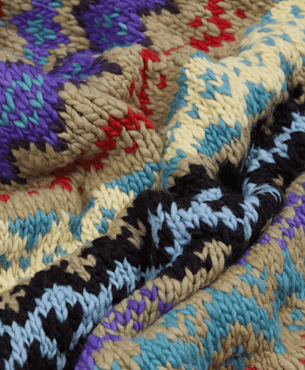 Close-up of a vibrant, chunky-knit textile with geometric patterns.