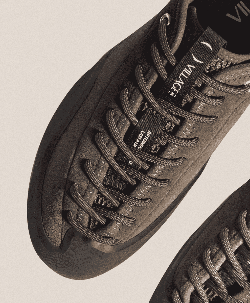 Macro shot of black textured suede and lacing system on a Village PM sneaker.