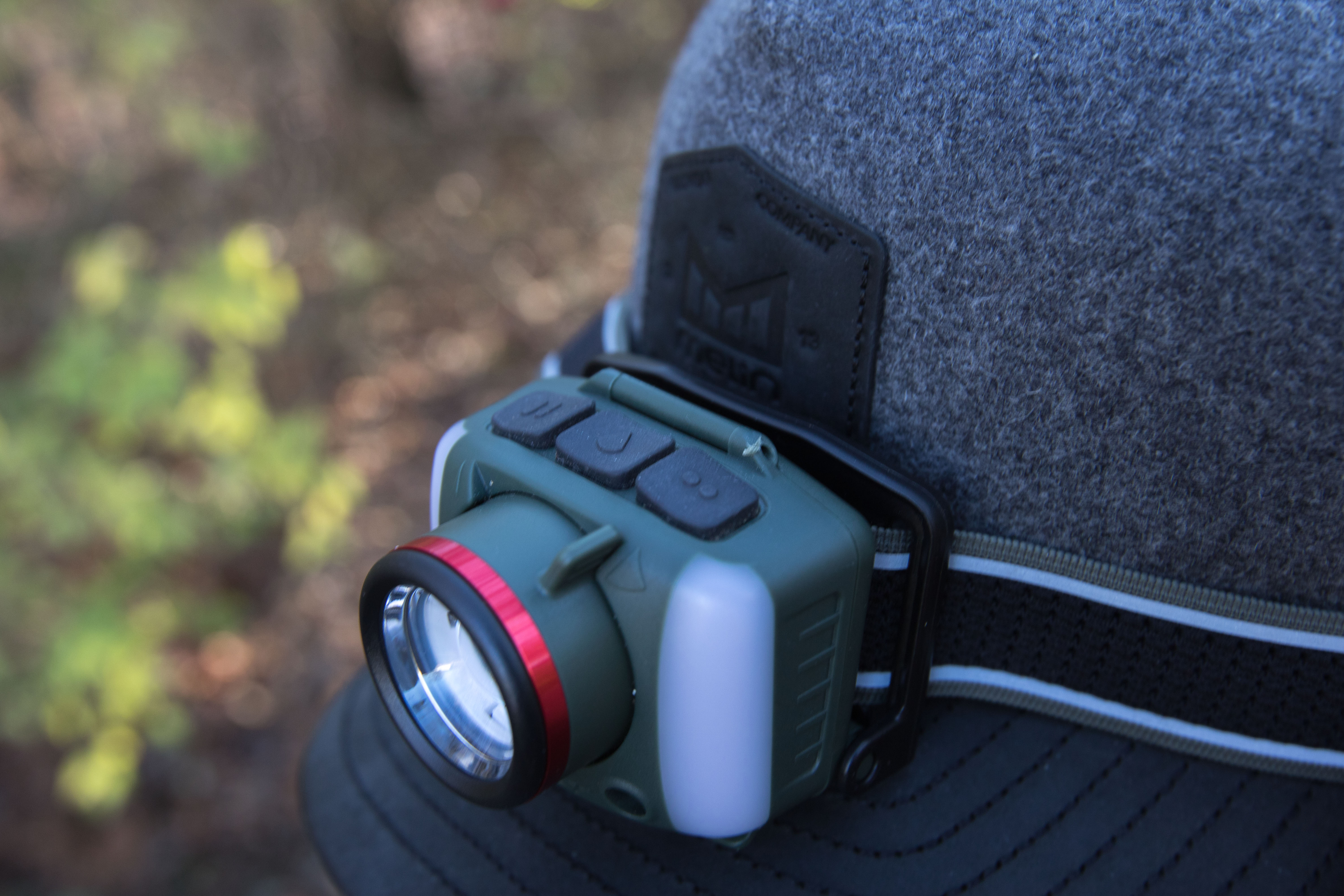 Top-down view of the FL97R headlamp mounted on a hat, highlighting its three main control buttons.
