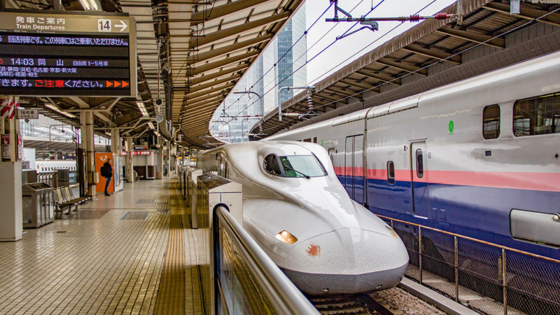 A Shinkansen bullet train at a station during the snowy winter season.