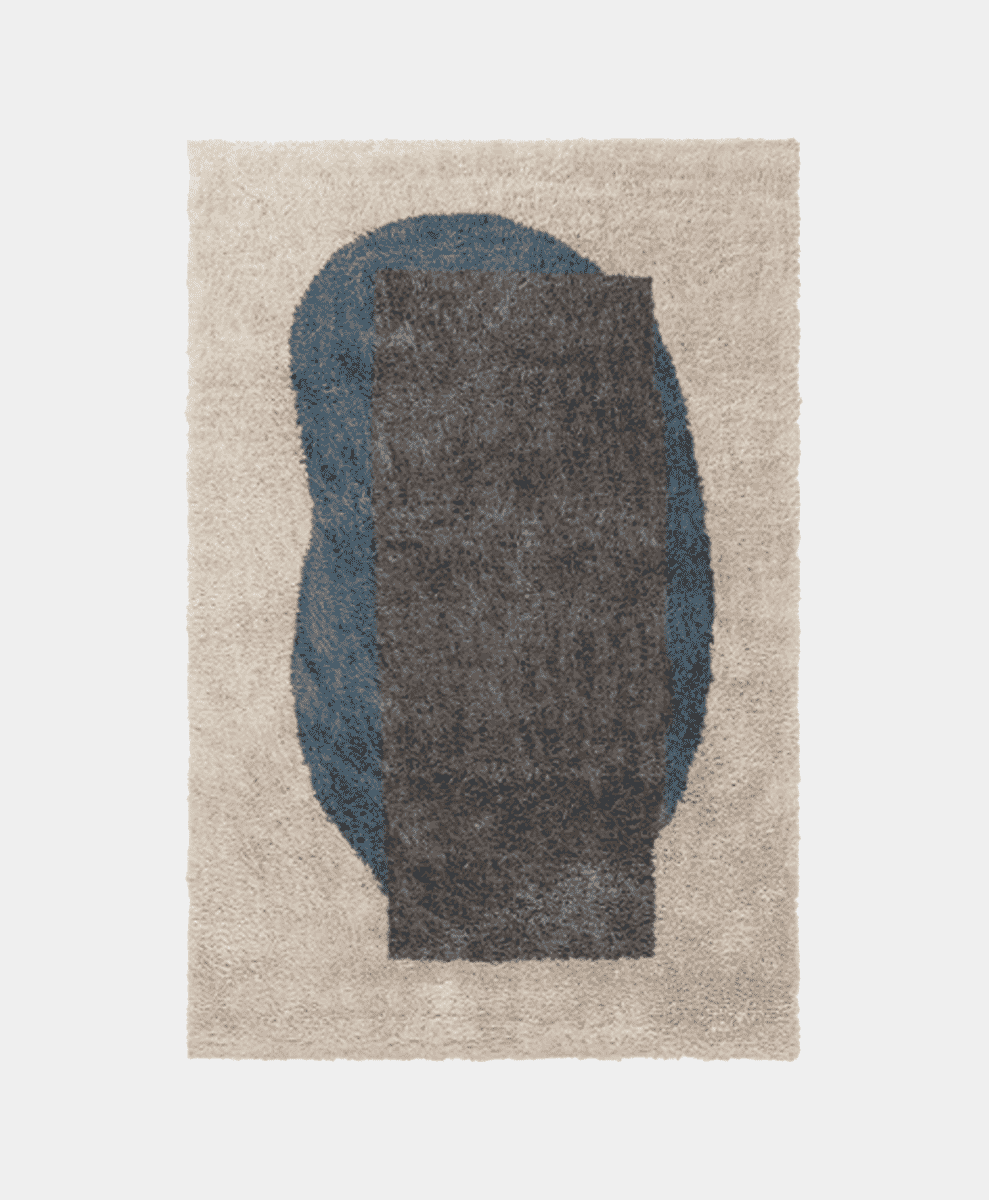 A modern abstract rug with beige, blue, and gray geometric shapes.