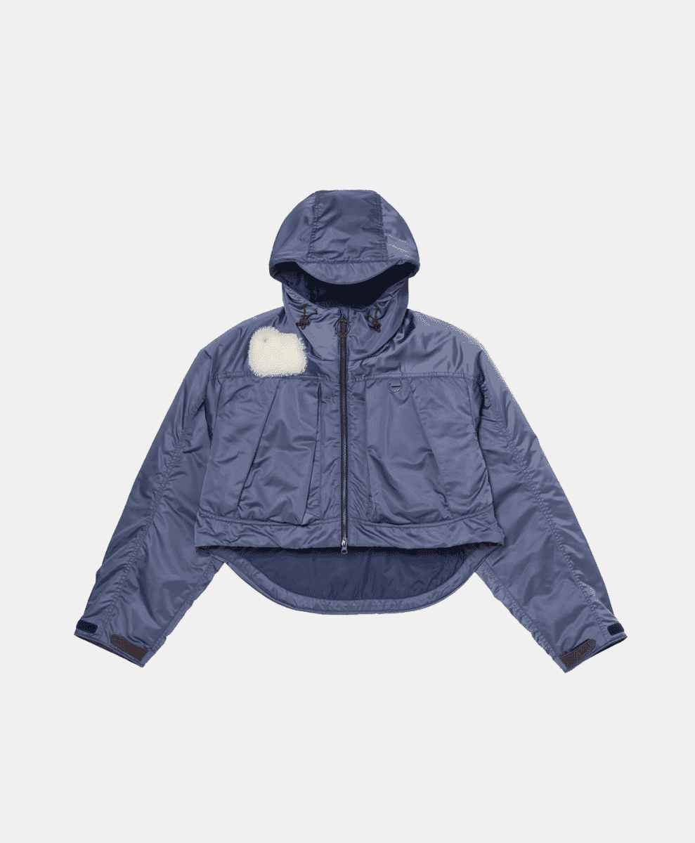 Muted blue-gray technical hooded jacket with a fuzzy chest patch.