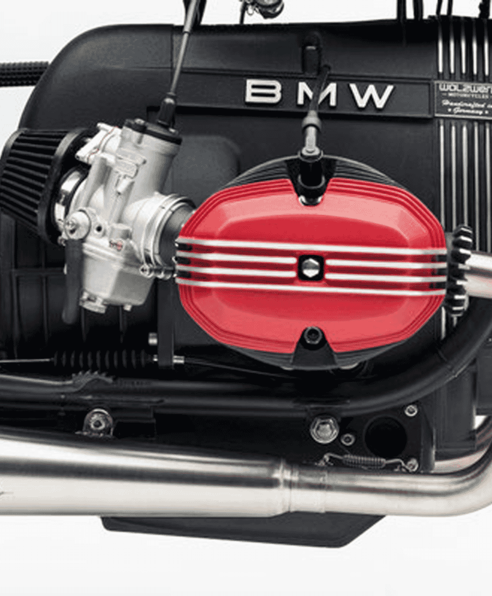 Detailed shot of the BMW motorcycle engine featuring red valve covers and silver mechanical components.