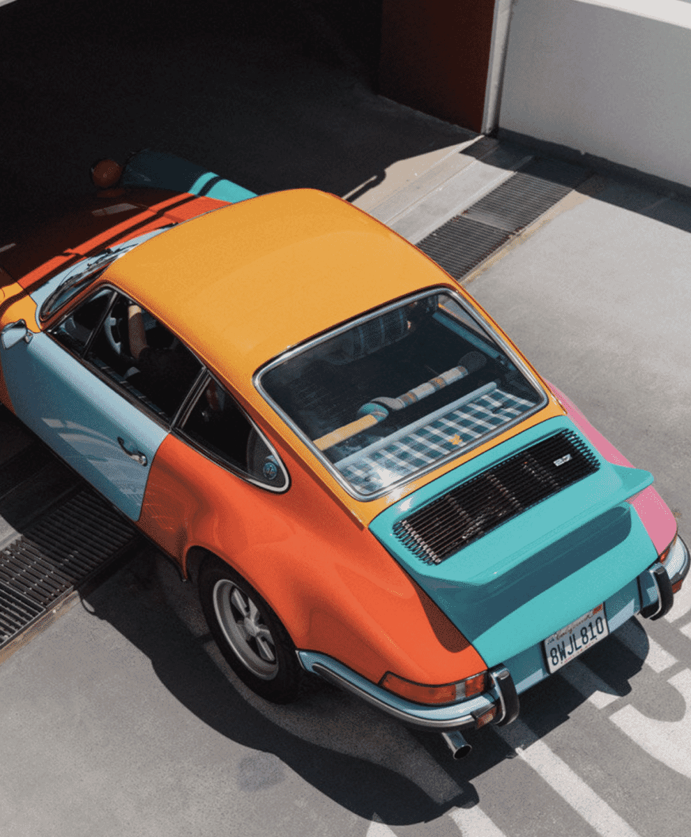 Top-down urban view of the multi-colored Porsche 911 Carrera RS on a city street.