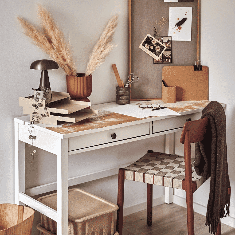 A cozy home office setup with a wooden chair, rustic decor, and pampas grass.