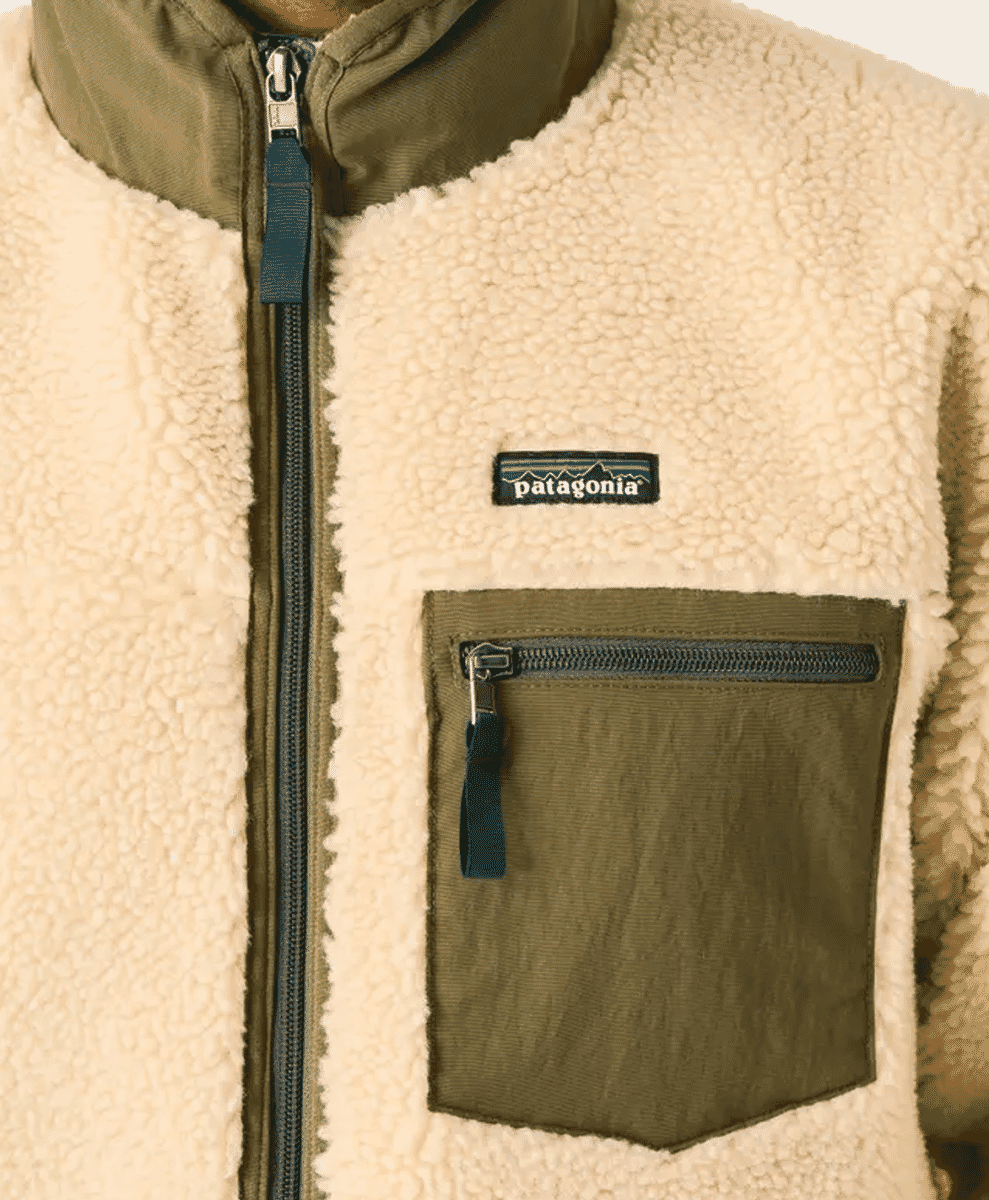 Close-up of a Patagonia fleece jacket with cream sherpa lining and olive green pocket accents.
