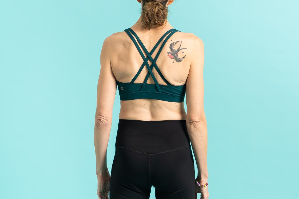 Rear view of a person wearing a compression sports bra showing cross-back strap detail.
