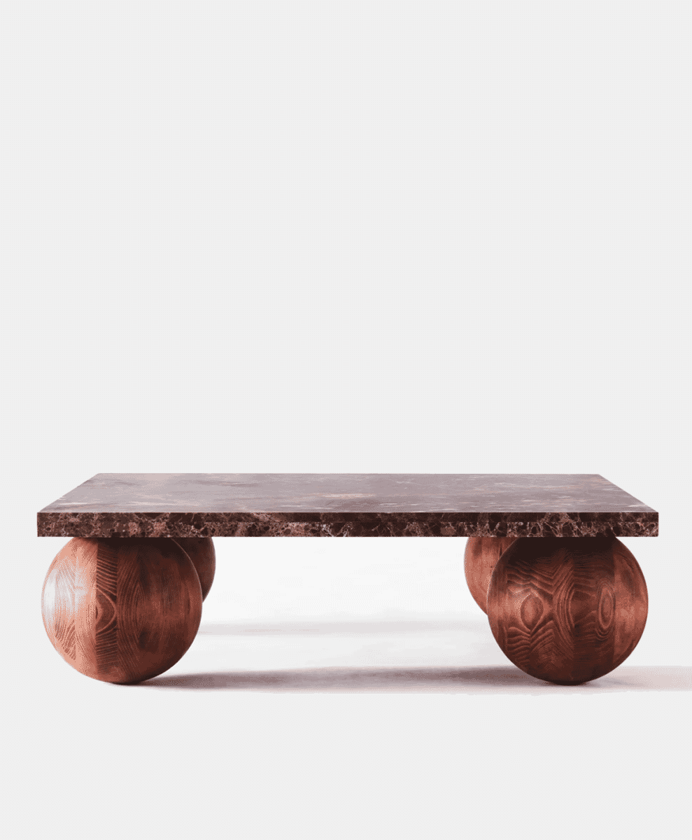 Modern coffee table with a dark marble top and spherical wooden legs against a white background.