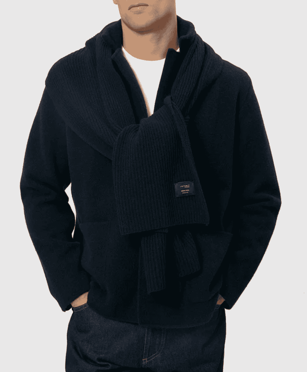 A man in a black ribbed knit shawl collar jacket layered over a white t-shirt.