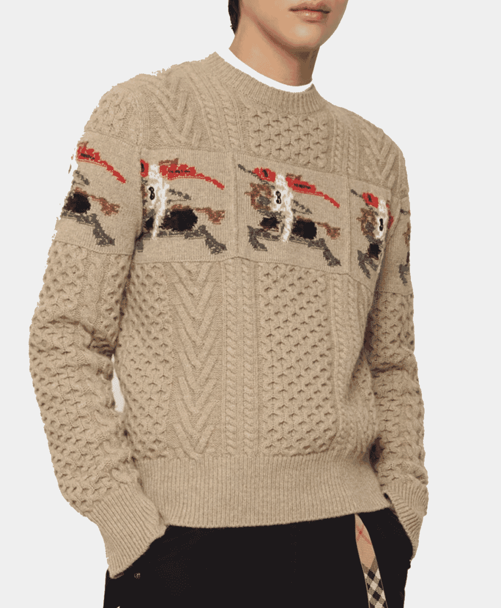 Model wearing a beige cable-knit sweater with horse and rider embroidery.