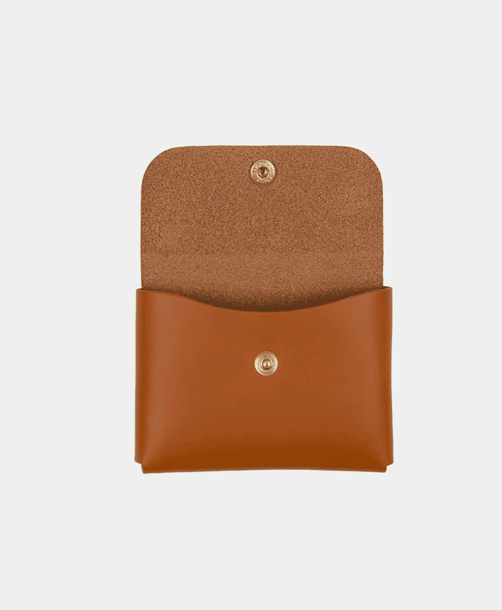 Open tan leather card case showing suede interior and gold-tone snap closures.