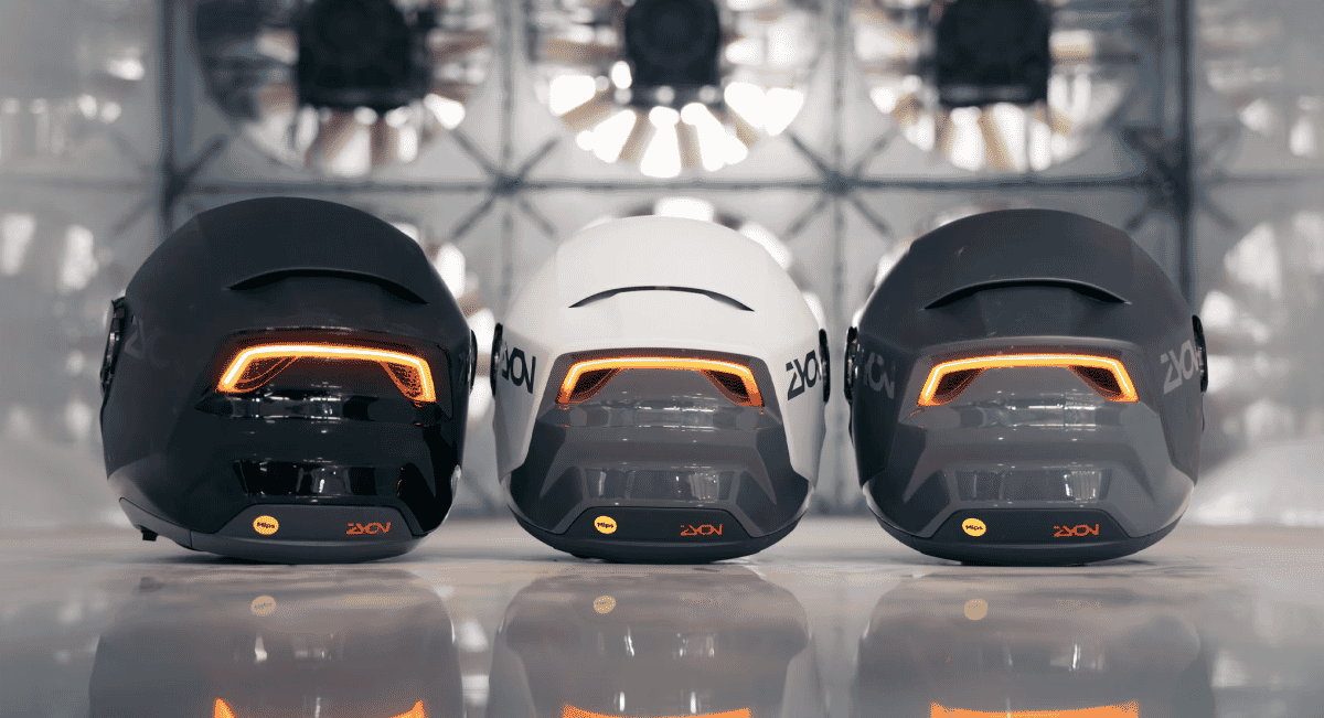 Three ZION helmets side-by-side with glowing orange rear lights