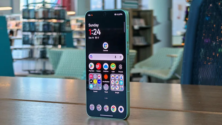 The OnePlus 15R sitting on a table, showing its flagship-inspired design.