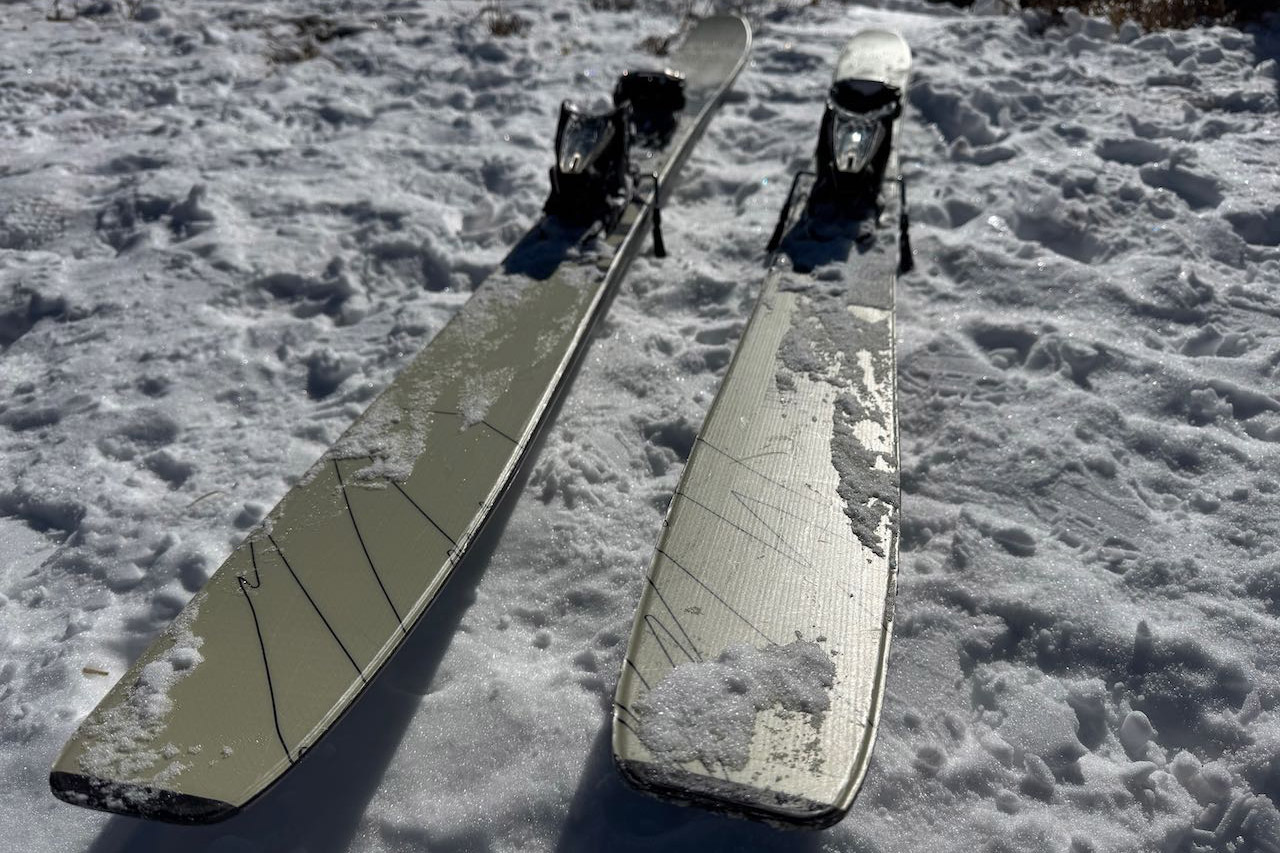 Top view of Völkl Revolt 101 skis lying flat on a snowy surface with bindings mounted.