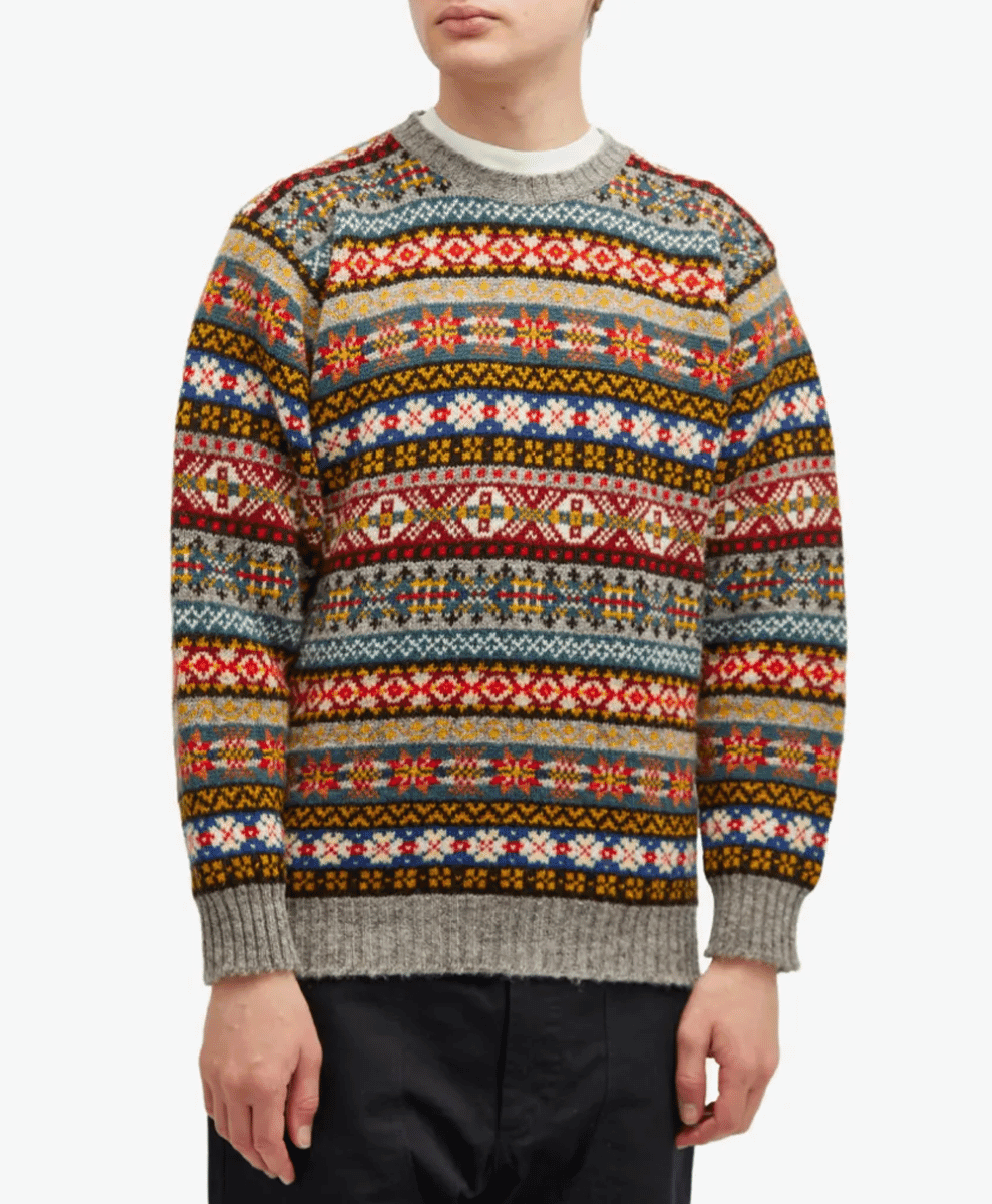 Model in a colorful Fair Isle knit sweater with floral and geometric motifs.