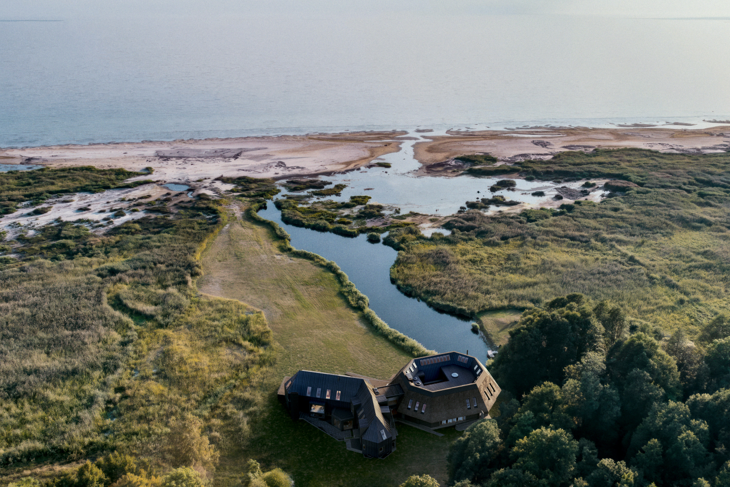 A serene coastal view looking out over cold blue waters from a minimalist wooden deck.
