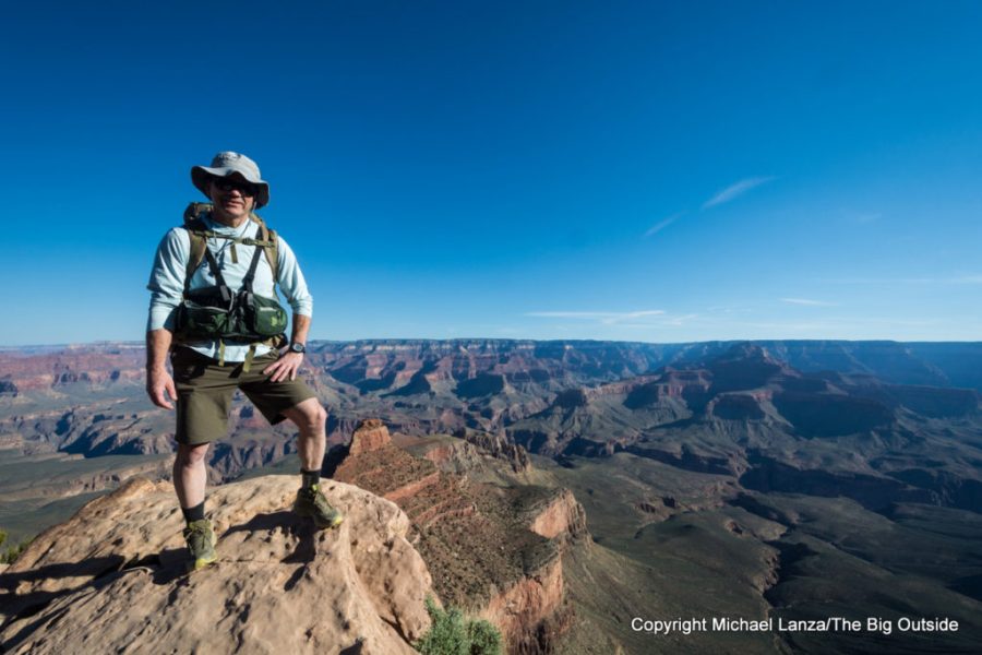 A hiker wearing a Patagonia Capilene Cool Daily Hoody in the bright, exposed landscape of the Grand Canyon.