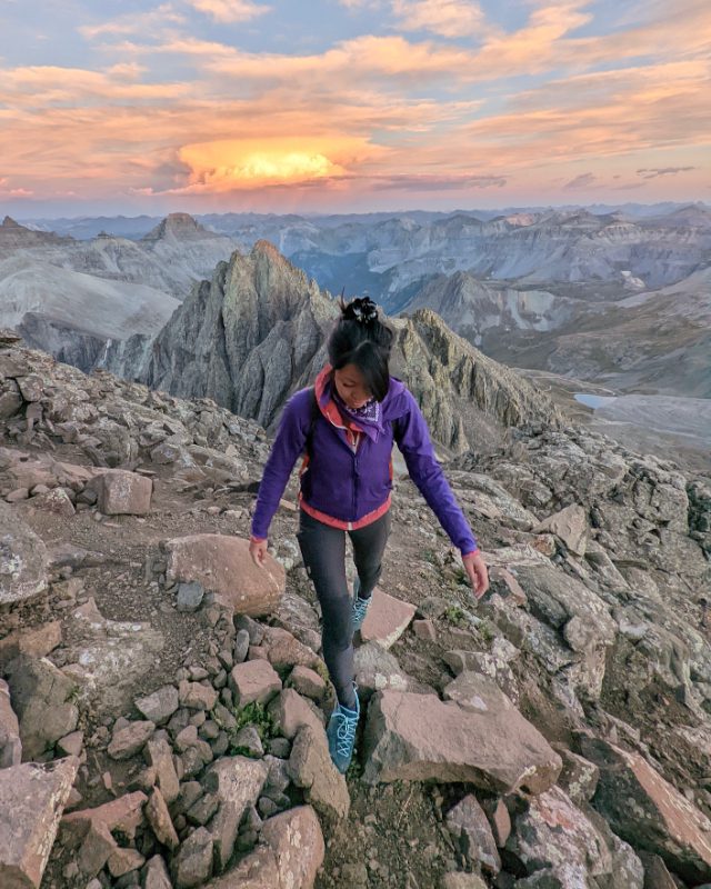 A hiker wearing Fjallraven Abisko trekking tights with reinforced panels on a mountain trail.