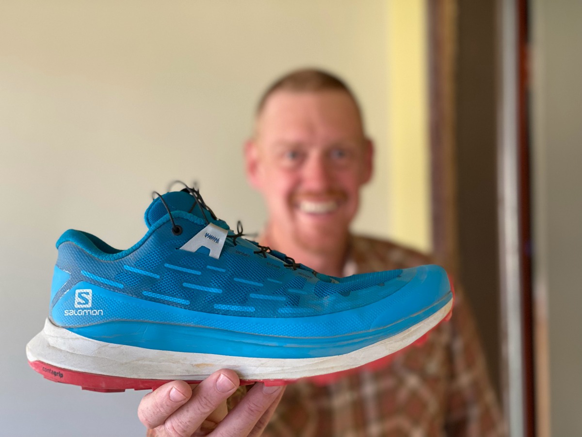 Bryon Powell testing Salomon trail running shoes on a dirt path.