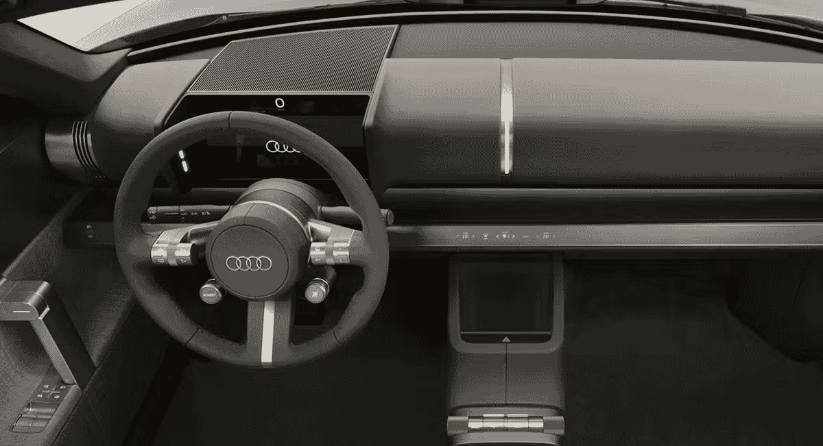 Close-up of a modern Audi steering wheel and digital dashboard interface.