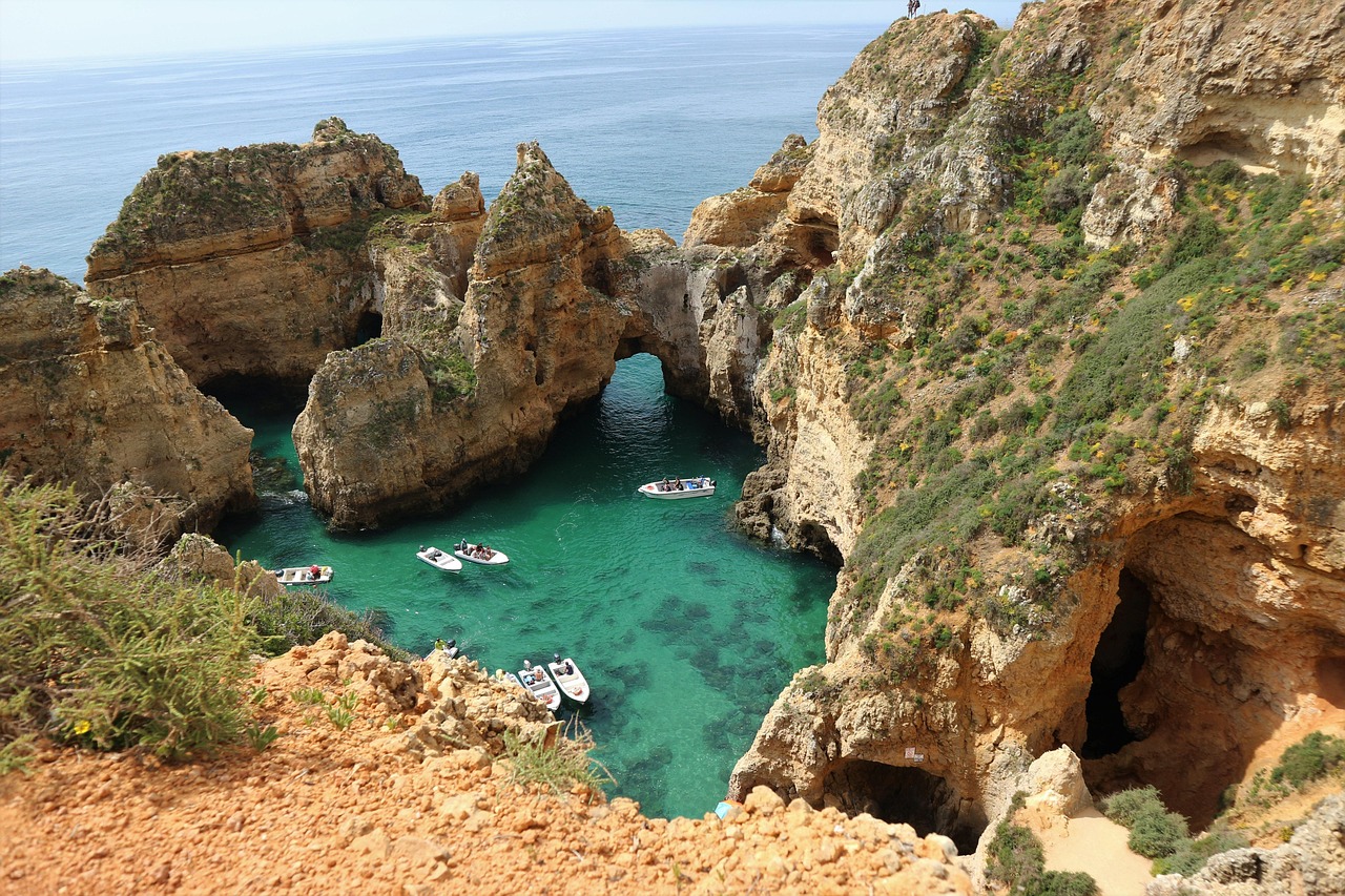 Golden limestone arches and turquoise water in the Algarve region.