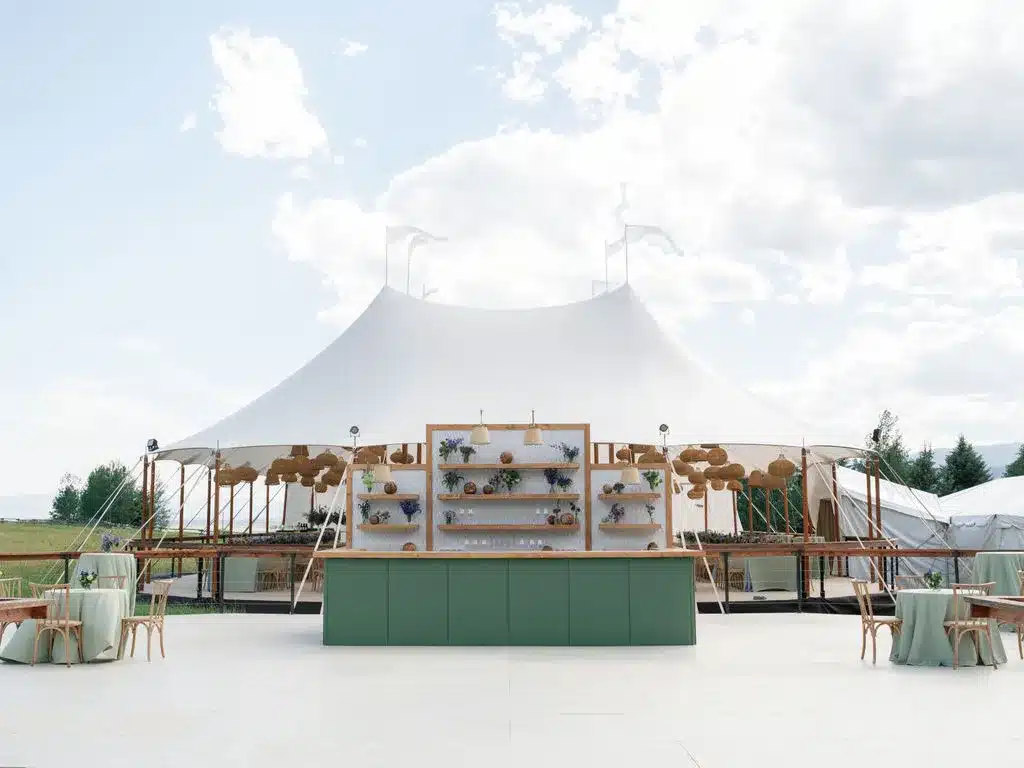 A diagram or clear shot showing a tent's orientation relative to wind direction and natural windbreaks.