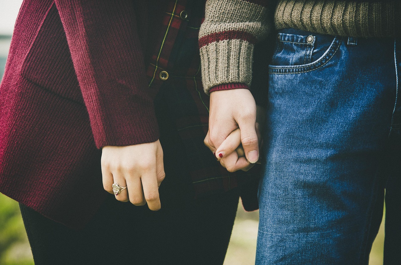 Close-up of hands holding a vintage printed photo of friends traveling together.