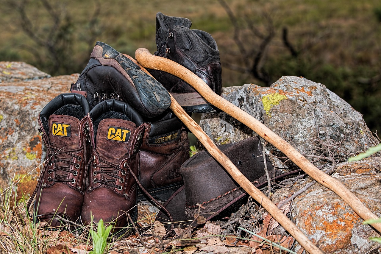 Close-up of rugged hiking boots trekking over a rocky mountain trail.